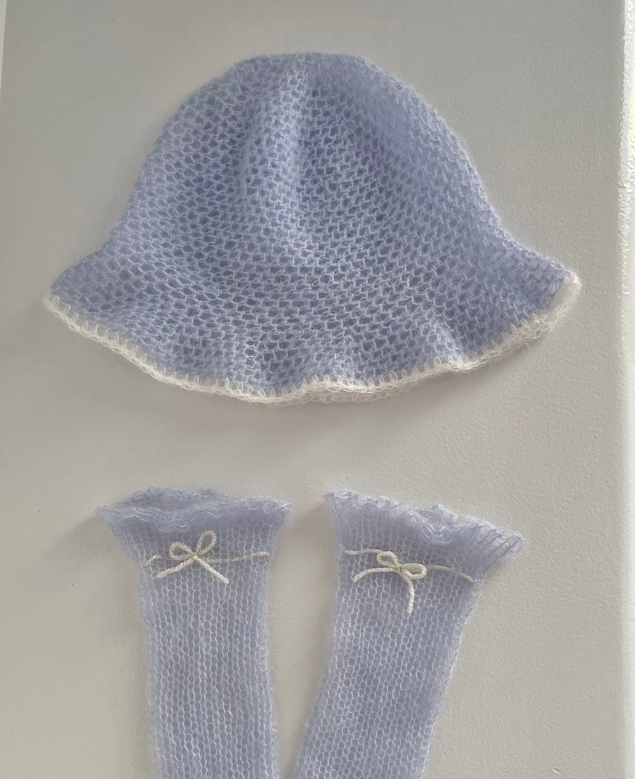 Handmade knitted mohair hand warmers in baby blue with beige bow